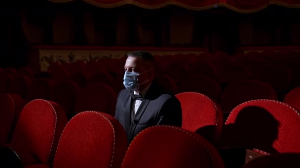 Adam Kırmızı Kadife Sandalyeli Boş Bir Salonun Ortasında Oturuyor Aktör — Stok video