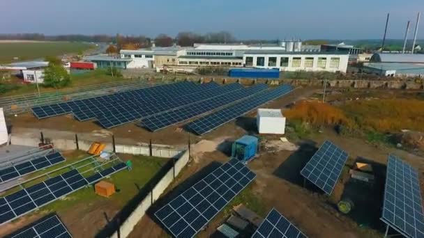 草のあるフィールドの背景にある太陽電池 ソーラーエネルギー製造工場 グリーンエネルギーコンセプト — ストック動画