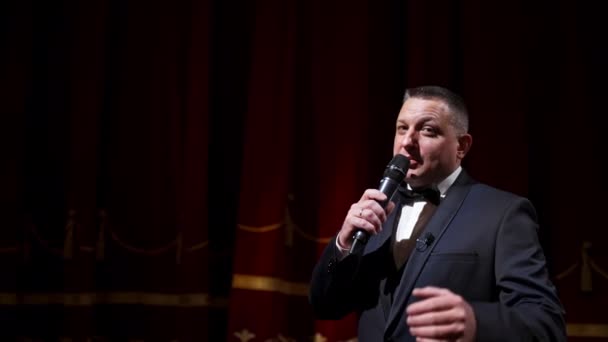 Moderator Mit Mikrofon Kündigt Auftritt Vor Publikum Von Der Bühne — Stockvideo