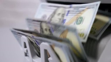 Para sayma makinesi. Banknotlar yüz dolarlık banknotları sayıyor. Yakın plan.