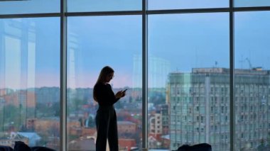 Gözlüklü, gülümseyen güzel bir kadın telefon kullanıyor.