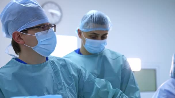 Skupina Lékařů Provádí Operaci Pacientem Chirurgové Lékařské Uniformě Maskách Pracující — Stock video