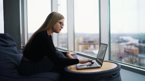 ノートパソコンで作業するメガネを持つ若い美しい女性 — ストック動画
