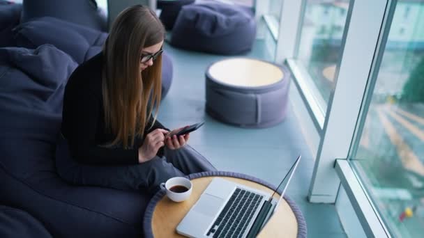 コーヒーを飲んでいる間ノートパソコンで働く美しい若い女性 — ストック動画