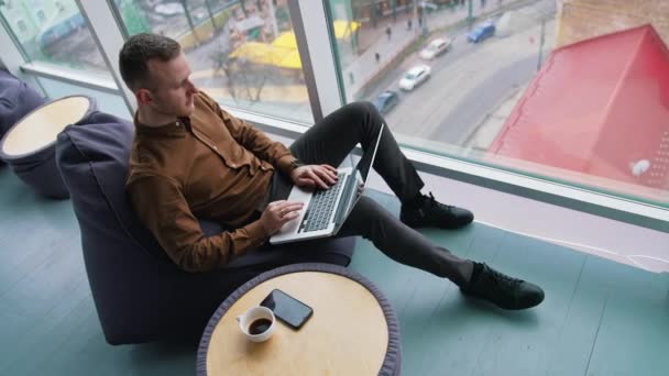 Férfi Dolgozik Laptop Miközben Karosszéken Közel Panoráma Ablak — Stock videók