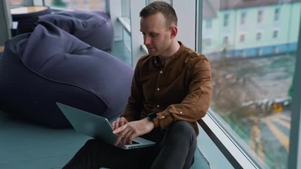 Egy Fiatalember Laptoppal Ablak Mellett Man Távolról Dolgozik — Stock videók