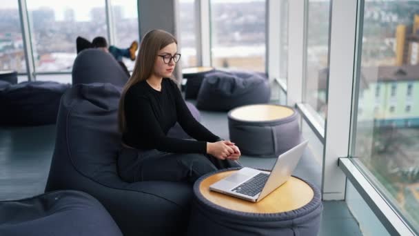 在笔记本电脑上工作的年轻女性戴着眼镜 — 图库视频影像