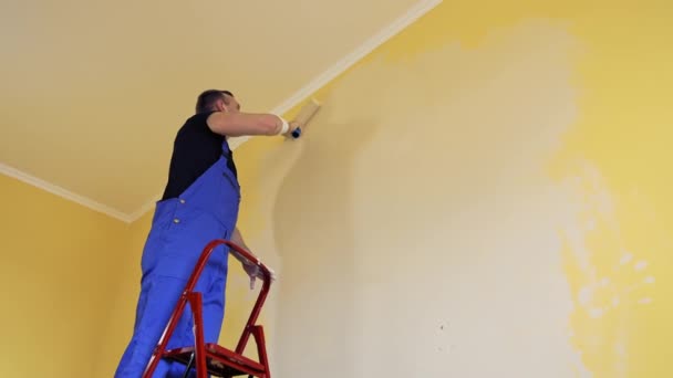 Mężczyzna Malujący Żółtą Ścianę Wałkiem Pracy Oferowanie Profesjonalnych Usług Malarskich — Wideo stockowe