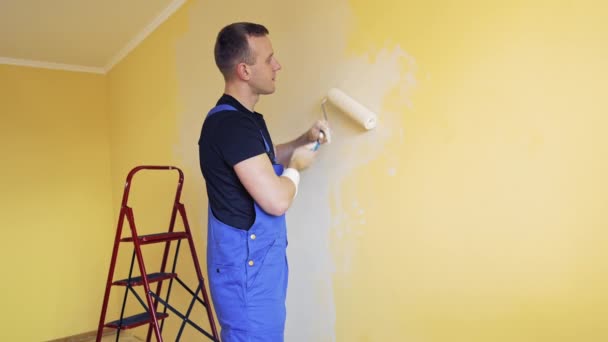 Giovane Operaio Pittura Muro Camera Offrendo Servizi Pittura Professionale — Video Stock