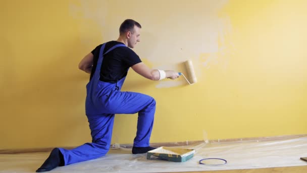 Młody Człowiek Maluje Ścianę Pędzlem Rolkowym Podczas Remontu Mieszkania Koncepcja — Wideo stockowe