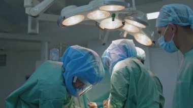 Ameliyatta. Hastane ameliyathanesinde tıbbi ekip operasyon yapıyor. Cerrahi aletlerle çalışmak.