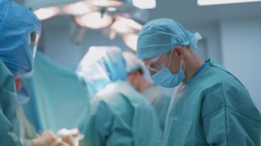 Ameliyathanede. Ameliyat masasında yatan bir hastaya ameliyat yapan bir grup doktor. Ameliyathanede üniformalı bir grup cerrah..