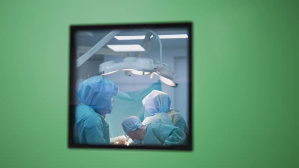 明るい現代手術室で手術を行っている医療チーム オペレーティングシアター クリニックの最新設備 — ストック動画