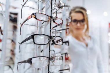 Göz kamaştırıcı bir göz giysisine hayran olan şık bir kadın. Bardakların önünde duran bir kadın.