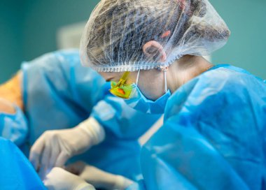 Profesyonel operasyon uzmanları çalışıyor. Bir grup cerrah hastane odasında..