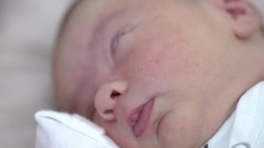 Sevimli bebek, eli yavrunun altındayken huzur içinde uyuyor. Pembe yanaklar, küçük burun ve dudaklar kapatın.