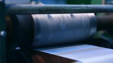 Küçük çıkıntıları olan büyük şaft hızla dönüyor. Bebek bezi üretiminde dönen büyük kuyu..