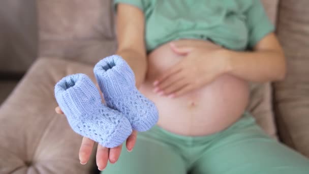 Madre Embarazada Sosteniendo Bonitos Calcetines Azules Palma Mano Madre Acariciando — Vídeos de Stock