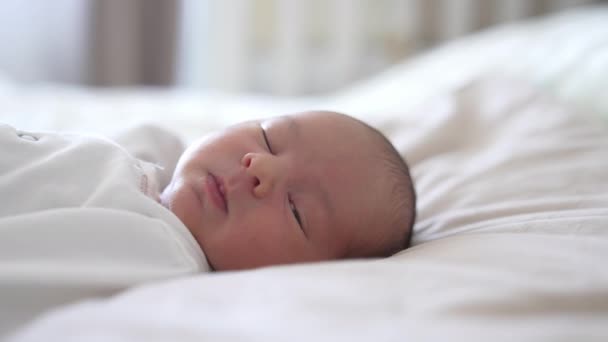 睡在床上的婴儿 宝宝在做梦的时候睁开眼睛 微微地笑着 一张漂亮的婴儿脸上的情感 — 图库视频影像