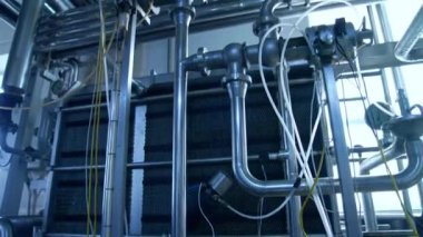 Süt ürünleri fabrikasındaki gümüş paslanmaz boru hatları. Modern süt kuruluşunda farklı çapta borular ve kontrol kutuları. Kapat..