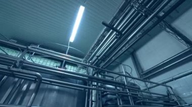 Birkaç çelik tüp birbiri ile çarpışıyor. Gün ışığı lambalarıyla aydınlatılan borular. Aşağıdan görüntüle.