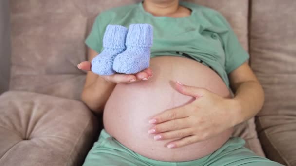 Inclinada Mujer Embarazada Sofá Acariciando Gran Vientre Con Una Mano — Vídeos de Stock