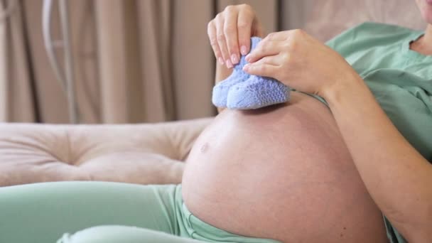 Madre Embarazada Está Sentada Sofá Jugando Con Pequeños Calcetines Bebé — Vídeos de Stock