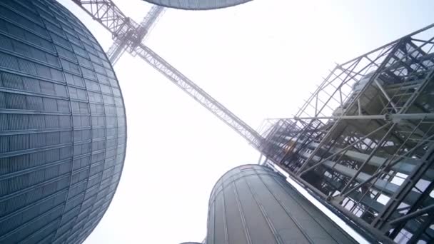 看着晶莹的天空 在巨大的粮仓电梯之间 白色天空背景下的高架之间的金属长桥 — 图库视频影像