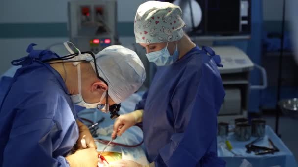 Двум Хирургам Делают Операцию Операционной Мужчина Женщина Ассистент Наклоняются Над — стоковое видео