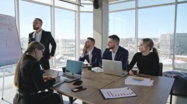 Geniş ofiste ekip toplantısı. İş görüşmesi ve iş arkadaşlarıyla beyin fırtınası. Her iki cinsiyetten iş arkadaşları ofiste toplantı yapıyor..