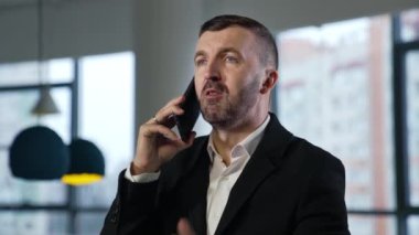 Cep telefonuyla iş konuşması. Ortaklara ya da müşterilere iş ziyareti. İş adamı akıllı telefonuyla konuşuyor..