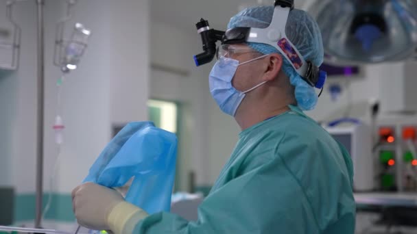 Άνδρας Χειρουργός Ειδικό Εξοπλισμό Στο Κεφάλι Στέκεται Πλάγια Γιατρός Κρατώντας — Αρχείο Βίντεο