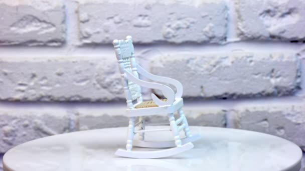 洋娃娃家的小白色摇椅旋转桌子上的家具相当小 后面是白色的砖墙 靠近点 — 图库视频影像