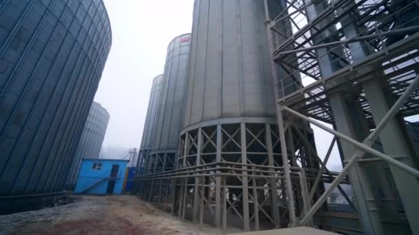 巨大的谷物仓钢罐矗立在巨大的金属支撑物上 离现代化工厂的粮仓基础越来越近了 — 图库视频影像