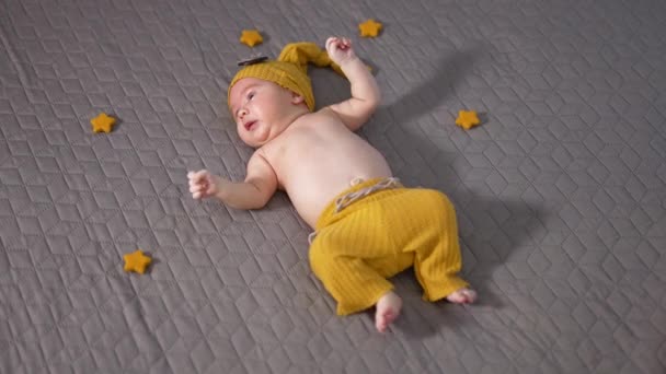 Schattig Kind Met Een Gele Hoed Broek Het Bed Kleine — Stockvideo