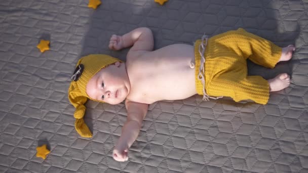 Büyük Düğmeli Geniş Pantolonlu Sarı Şapkalı Çocuk Yatağın Üstünde Kocaman — Stok video