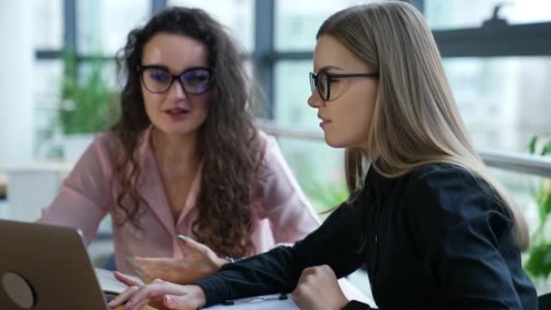 Две Женщины Офисе Сидят Перед Ноутбуком Обсуждают Стратегии Деловой Разговор — стоковое видео