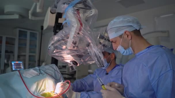 作動中に神経外科医が使用する高精度機器 顕微鏡の動作をチェックする医師 — ストック動画