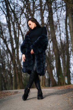 Siyah ceketli ve siyah çizmeli bir kadın.