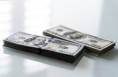 Masadaki 100 Dolarlık banknotlar yığını. Masanın üstünde duran 100 dolarlık banknotlar.