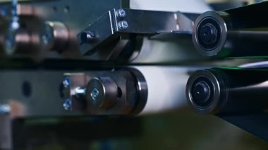 Fabrikada bebek bezi üretiminin teknolojik süreci. İki paslanmaz çelik rulo örülmemiş kumaşla dönüyor. Kapat..