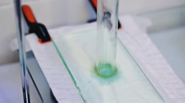 Bebek bezi laboratuvarı üretimi. Girişimdeki bebek bezi katmanlarının emme yeteneklerini test ediyorum. Kapat..