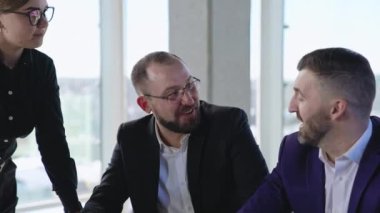Ofiste iki erkek ve bir kadın iş tartışıyorlar. İş arkadaşlarıyla buluşup çözümler ve stratejiler arıyorlar. Kapat..