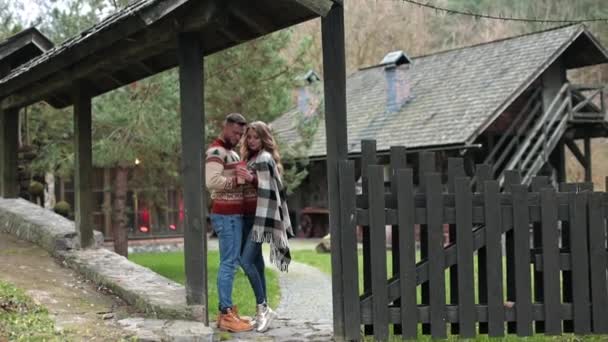 同様のセーターの魅力的なカップルは 管理者の門に立っています 田舎の秋の季節でした 大都市の外で居心地の良い時間を過ごす — ストック動画