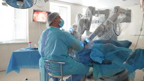 Αρσενικός Χειρουργός Αρωματίζει Την Επέμβαση Βοήθεια Ρομποτικού Εξοπλισμού Οθόνη Εσωτερικά — Αρχείο Βίντεο
