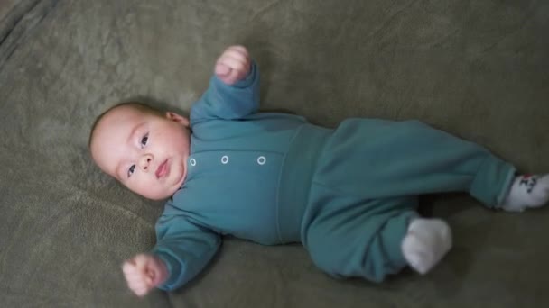 Cute Kid Lying Bed Blue Suit Baby Tossing His Feet — Stock Video