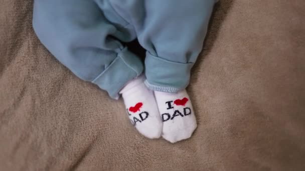 可爱的婴儿的脚穿着小袜子 我爱你 爸爸袜子踩在灰色背景的小脚上 靠近点 — 图库视频影像