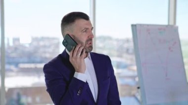 Başarılı bir iş adamı akıllı telefondan konuşuyor. Resmi takım elbiseli adamın telefonda iş görüşmesi var. Kapat..