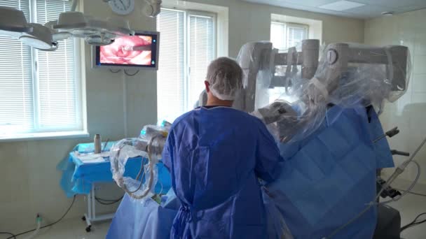 Cirurgião Está Costas Para Câmara Médico Executando Operação Usando Robô — Vídeo de Stock