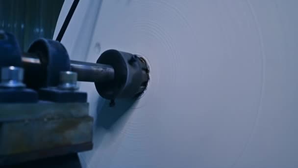 白いリボンの巨大な回転ロール 工場でおむつを製造するために使用される布のリール クローズアップ — ストック動画